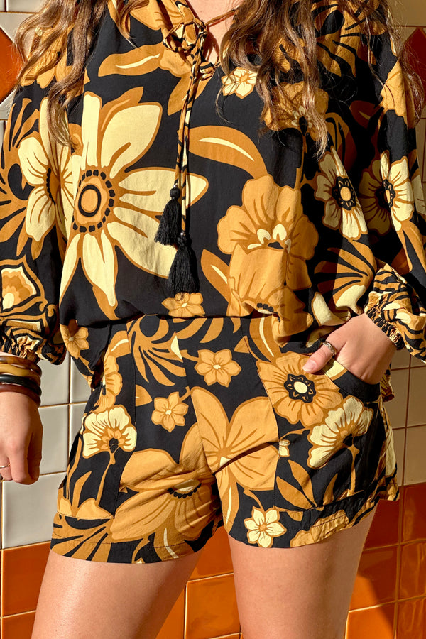 Vintage inspired high waist shorts with patch pockets  in a large scale floral print in brown and gold tones with a black background