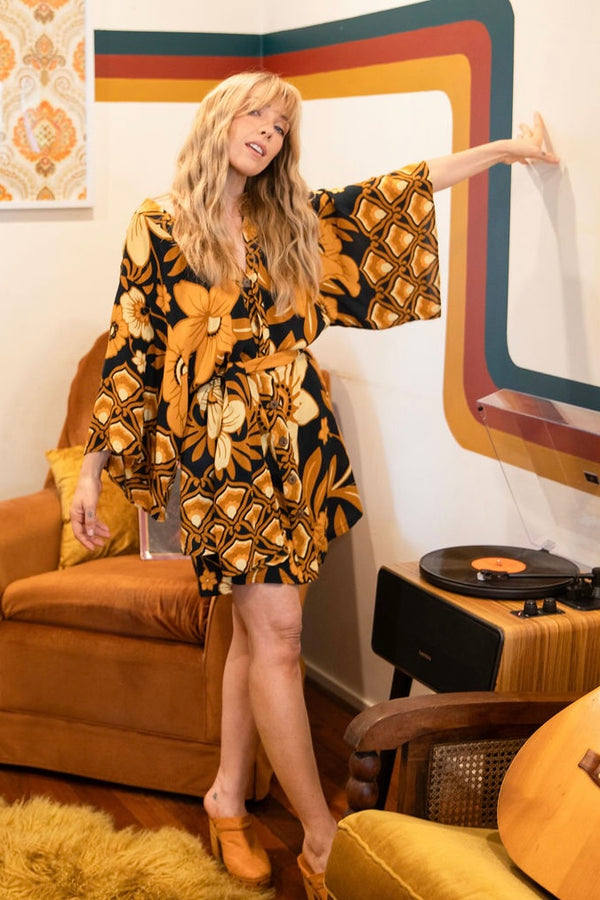 Vintage inspired bohemian style button up smock dress in a large scale floral print in brown and gold tones with a black background