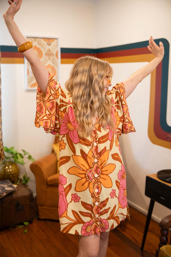 Vintage inspired bohemian style button up smock dress in a large scale floral print in pink and orange with a buttery cream  background