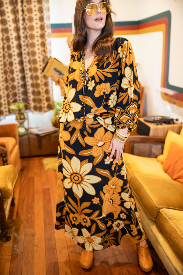 Vintage inspired A-line high waist maxi skirt in a large scale floral print in brown and gold tones with a black background