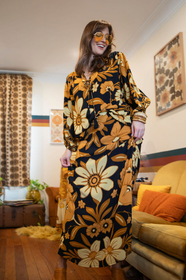 Vintage inspired A-line high waist maxi skirt in a large scale floral print in brown and gold tones with a black background