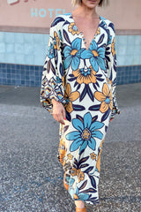 70s vintage inspired boho midi dress with bold retro floral print in blue,tan and navy on a cream background, bell sleeves and side splits. Made in rayon