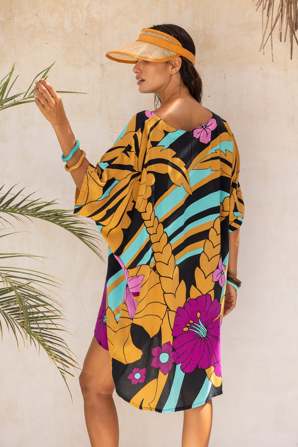 Large scale retro palm print flowy summer resortwear kaftan dress with round neckline batwing style 3/4 sleeves and drapes longer at the back  100% rayon black magenta and aqua colourway with colourful bangles to compliment