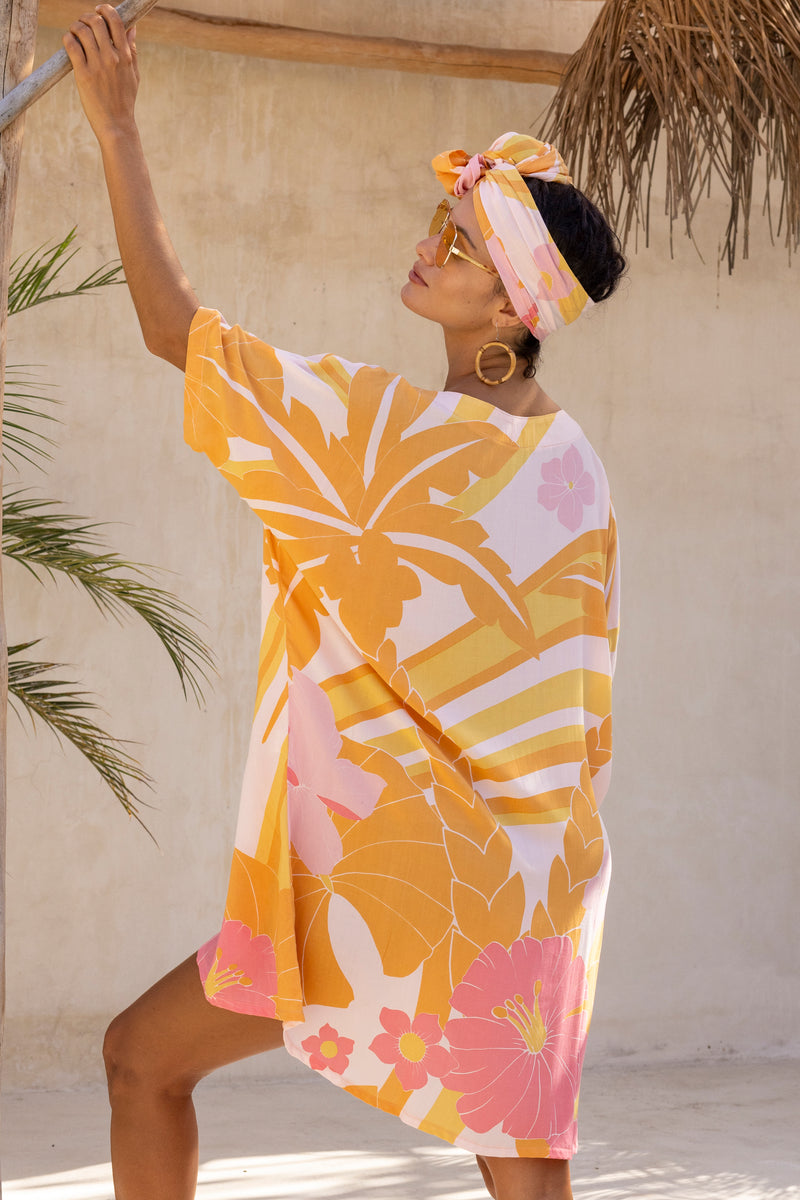 Large scale retro palm print flowy summer resort wear kaftan dress with round neckline batwing style 3/4 sleeves and drapes longer at the back  100% rayon  flamingo pink colourway with matching head wrap and bamboo earrings to compliment